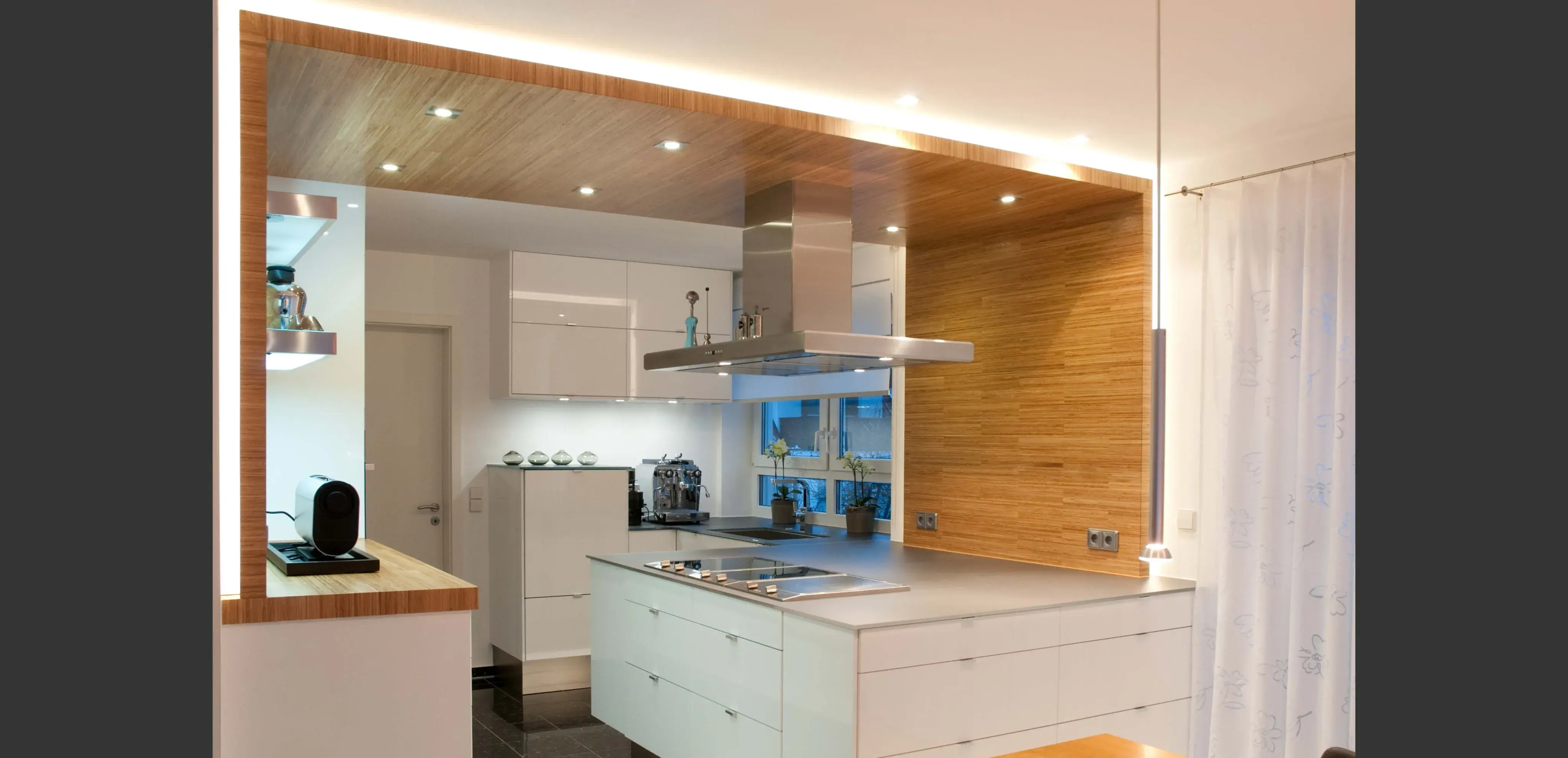 Moderne Küche mit weißem Interieur, Holzakzenten und heller LED-Beleuchtung.