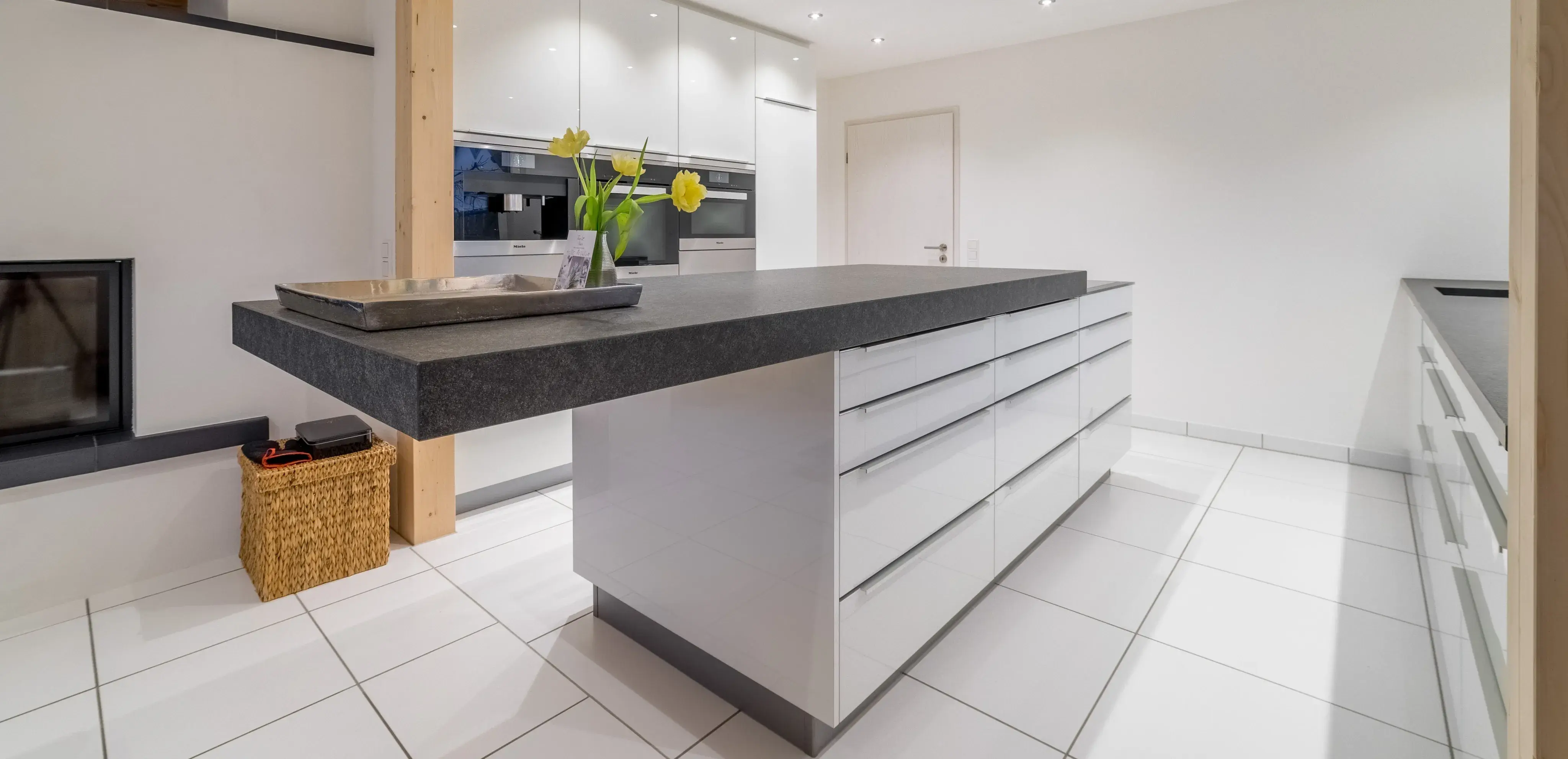 Moderne, helle Küche mit großer Kücheninsel und weißen Fliesen.