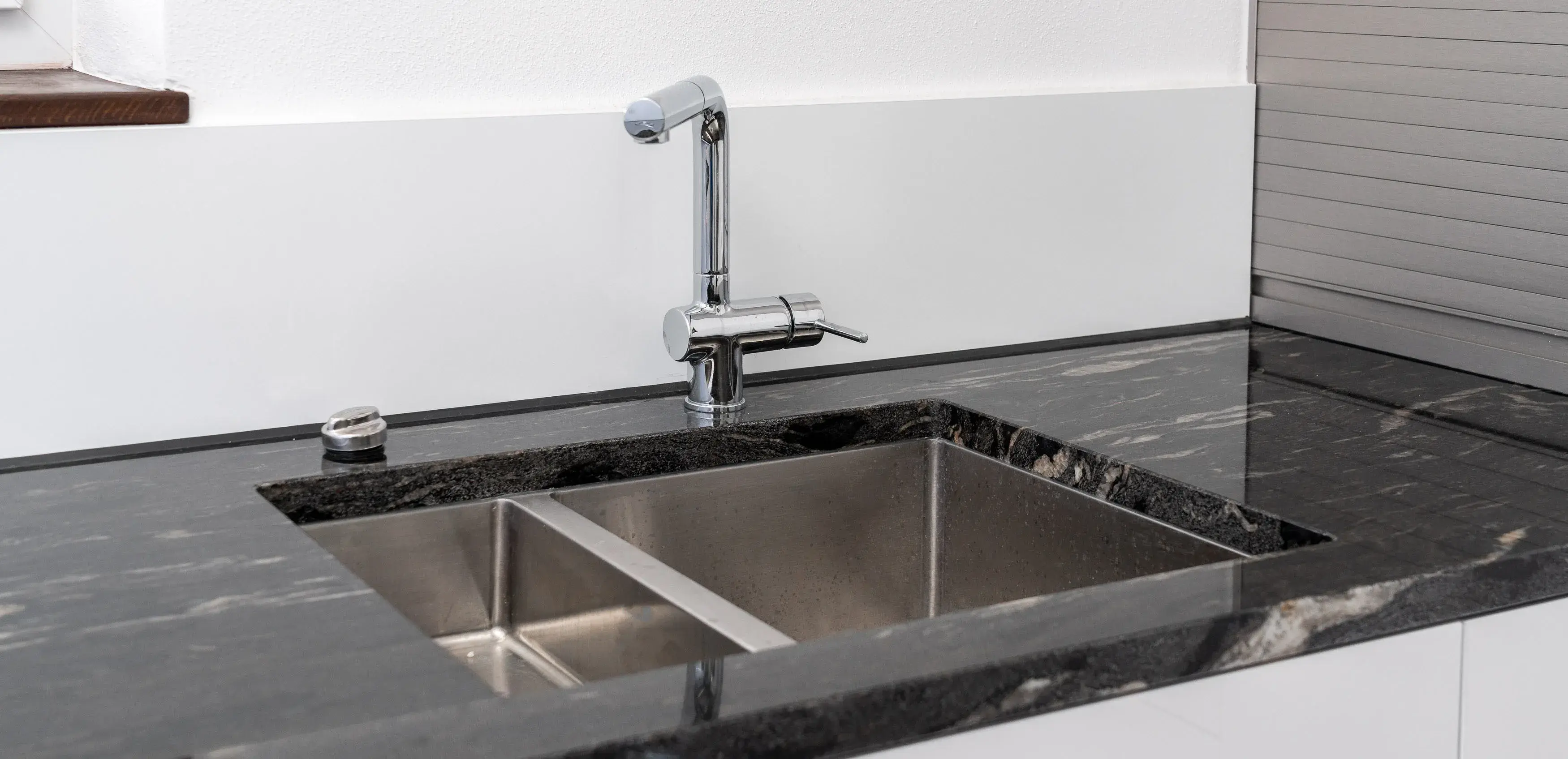 Moderne Spüle mit Edelstahlbecken und Marmorarbeitsplatte in einer Küche