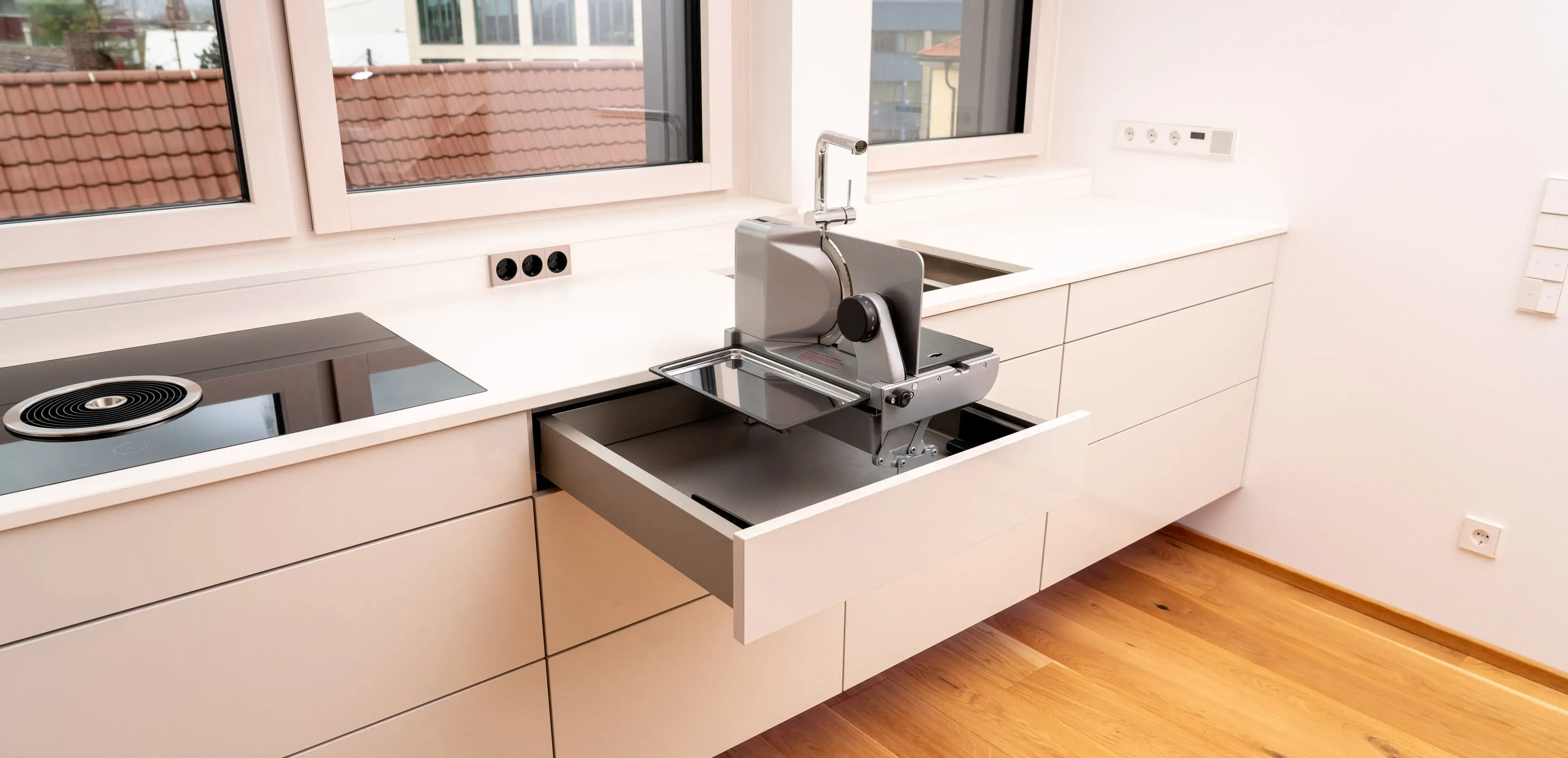 Moderne weiße Küche mit ausziehbarem Geschirrspüler in einer Schublade.