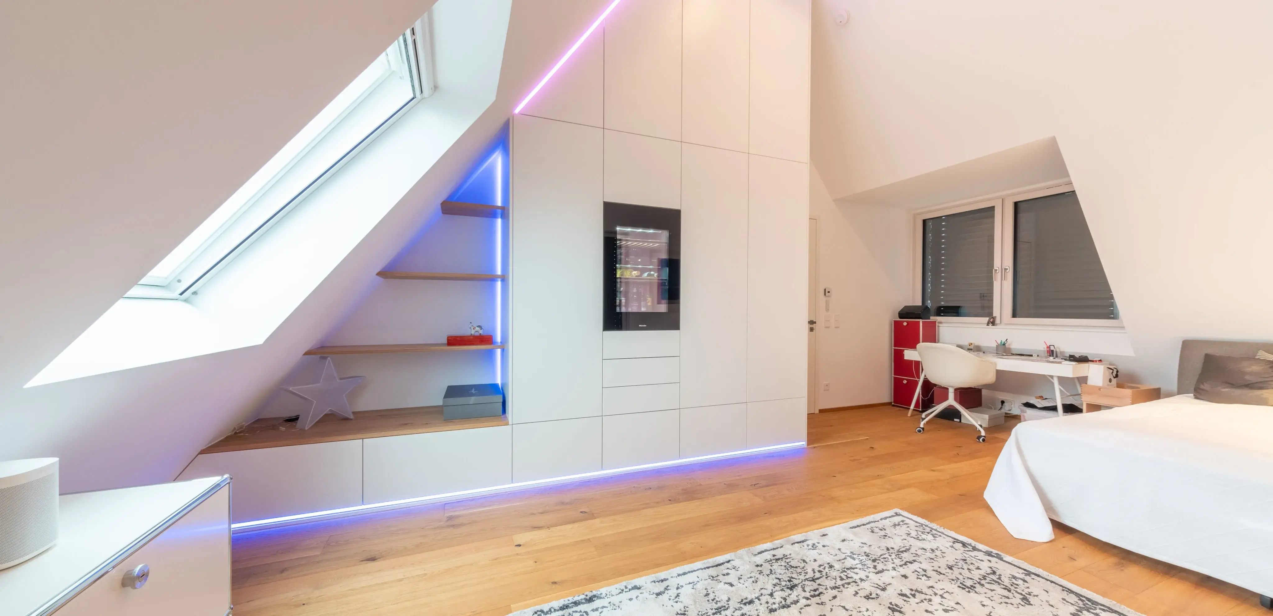 Modernes Dachzimmer mit weißen Möbeln, Holzfußboden und LED-Beleuchtung.
